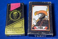 Two vintage tarot card boxes, one Dishonored Tarot Deck, one featuring FOL tarot card on the box (Aquarian). Both boxes show minor wear.