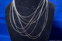 Front view of the sterling silver chains displayed on a black bust showing varying chain styles and lengths.