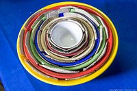 Top view of all eight nesting mixing bowls showing nested arrangement with colorful rims visible.