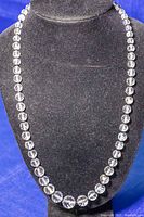 Full length shot of clear faceted bead necklace displayed on black bust stand showing bead size and bead count.