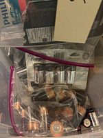 Close-up photo showing batteries including Energizer Max AA and D size batteries, and various loose button cells in plastic bags.