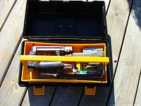 Top view of toolbox containing three pneumatic upholstery staplers and boxes of staples