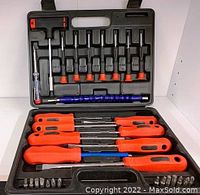 Open black plastic storage case showing the screwdriver set including red and black handled screwdrivers, bits, and extension pieces.
