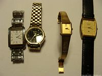 Four Seiko watches displayed on a white surface showing different styles and bands.