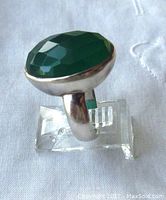 Side view of silver ring with prominent oval faceted green quartz stone