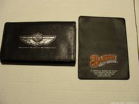 Closed black leather wallet with Harley Davidson 100 Years logo (1903-2003) and plastic card holder with Barrie Harley Davidson branding.