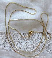 Full length of chain laid out on lace fabric showing entire necklace and clasp