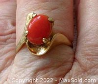 Front view of the vintage 14K gold ring showing salmon color coral cabochon and stylish band design.