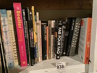 Shelf of Beatles books showing a mix of soft and hardcover works including diaries, biographies, and FAQs by various authors.