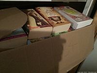 Box of books with visible titles including 'The Hunger Games','City of Ghosts','The Midnight Library'