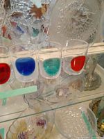 Image showing four glasses with colored circles: red, blue, green, and orange around the bottom of each glass