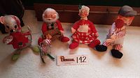 Photo of assortment of five Annalee Christmas dolls including two mice, Santa Claus, female and male human figures in festive outfits on carpet.