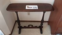 Front view of the antique wooden sofa table showing the rectangular top and turned legs.