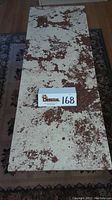Top view showing the Italian marble top with mottled brown pattern on cream background and the lot number card.