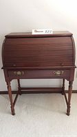 Front view of the entire vintage Pennsylvania House roll top desk, showing the tambour roll top closed, drawer pulled closed, turned legs, and brass handles.