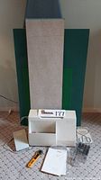 Wide shot showing sewing machine with foot pedal, rotary cutter, bobbins, accessories, instruction manual, and ironing board.