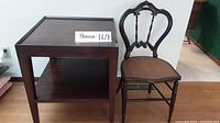 Full view of wooden end table and vintage side chair next to it