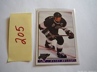 Front of 1993 OPC Premier Wayne Gretzky hockey card showing player in black hockey uniform skating.