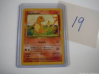 Charmander Pokémon card in protective sleeve with handwritten lot number 19.