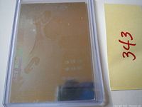 Holographic card surface viewed from an angle showing faint text and reflective properties.