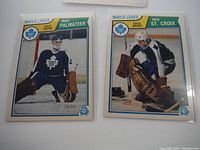 Front photo of Mike Palmateer and Rick St. Croix hockey cards showing the players in goalie poses wearing Toronto Maple Leafs uniforms and goalie pads.