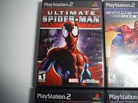 Close-up photo of Ultimate Spider-Man PlayStation 2 game case showing cover art, ESRB Teen rating and Marvel, Activision logos.
