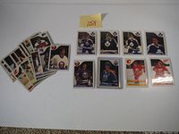 24 various vintage hockey cards laid out on white surface including multiple Toronto Maple Leafs players and others from different NHL teams.