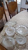 Photo showing various vintage glassware including the covered bowl with turkey motif, divided relish dish, covered candy dish, and small bowls displayed on table.