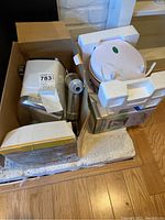 Egg waffle maker in white casing, partially wrapped in foam packaging, showing compact appliance shape.