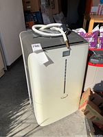 Front and side view of white portable air conditioner unit with attached exhaust hose.