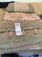 Full view of folded king size comforter with button details and matching shams.