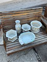 Overview of five porcelain pots on wooden bench