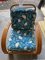 Top-down view of vintage bamboo armchair showing blue floral cushions with beige flowers and green stems.