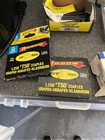 Boxes of Arrow T50 staples in 1/4 inch (6mm) and 9/16 inch (14mm) sizes, black packaging with yellow accents.