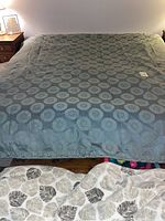 Full view of the brocade bedspread laid out flat on a king size bed, showing overall pattern and sheen of fabric