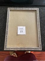 Front view of the metal picture frame showing the overall rectangular shape and decorative border.