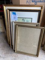 Four picture frames stacked together showing their front styles and sizes, including a price tag sticker on one frame.