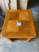 Top view of wooden side table showing parquet pattern top and overall finish.