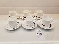 6 bone china mugs with matching saucers arranged in two rows on a white surface