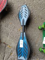 Top view of blue ripstick waveboard showing leaf-like perforation patterns on black grip padding.