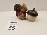 Overall view of the squirrel and acorn ceramic shakers side by side with size reference
