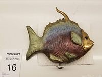 Front view of entire fish sculpture showing iridescent patina and mounting screw