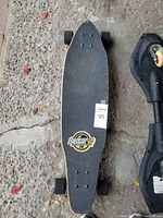 Top view of the skateboard showing Sector brand logo on black grip tape surface and signs of wear on edges.