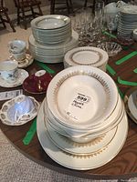 Stacked Myott China plates with Tiffany pattern in gold on white porcelain, including large dinner plates and smaller side plates.