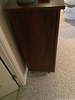 Side view of teak veneer cabinet showing wood grain and finish.