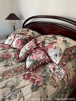 Close-up image of headboard and pillows showing cherry wood frame and floral silk damask fabric with detailed texture and colors.