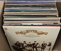 Full view of vinyl record lot showing a stack with Little River Band's Diamantina Cocktail album cover visible.