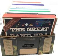 Photo showing several boxed record sets in a black cardboard carrier. Front set titled 'The Great Band Era' labeled collector's edition and original recordings.