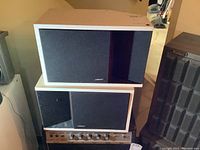 Pair of Bose 201 Series II white painted speakers stacked, showing front with black grille covers and Bose logo