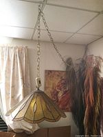 Full view of stained glass swag lamp hanging from ceiling chain